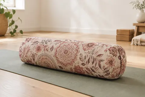 Bolster de yoga rond en coton imprimé, posé sur un tapis dans un studio lumineux au sol en bois clair