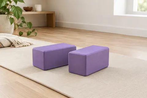 Deux briques de yoga violettes en mousse EVA posées côte à côte sur un tapis écru
