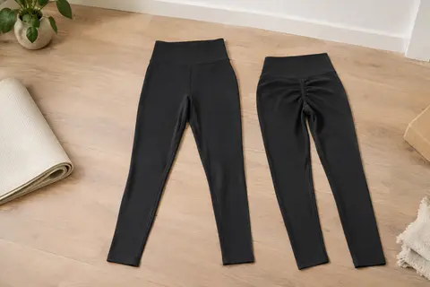 Legging de sport noir foncé à taille haute et effet froncé, présenté à plat dans un studio lumineux.